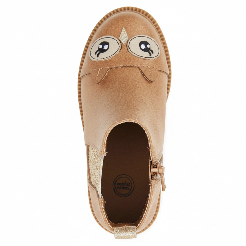 Angled 3/4 top view of girls tan owl chelsea boot showing owl face detail, gold elastic panel and brown insole on clean white background