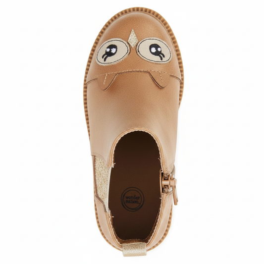 Angled 3/4 top view of girls tan owl chelsea boot showing owl face detail, gold elastic panel and brown insole on clean white background